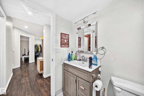 Bathroom vanity featuring a light wood-finish cabinet, white countertop, and rectangular sink - 12410 171A Avenue, Edmonton, AB 