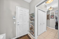 Entryway featuring a white paneled door, light gray walls, and light tile flooring - 