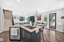 Kitchen island with a granite countertop, double basin sink, and integrated dishwasher - 
