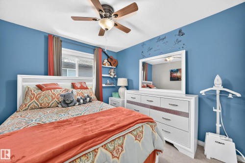 Bedroom featuring a white framed headboard, a ceiling fan with light fixture, and a window with blinds and drapes - 12410 171A Avenue, Edmonton, AB 