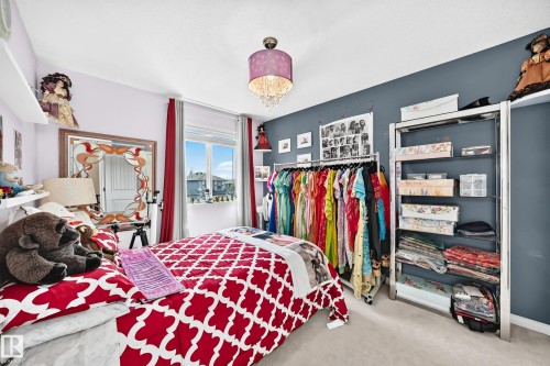 Light-filled room featuring a double window, wall-mounted shelving, and a decorative ceiling light fixture - 12410 171A Avenue, Edmonton, AB 