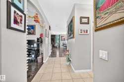 Tiled entryway with light gray walls, white baseboards, and a decorative archway - 