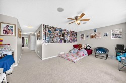 Carpeted room with a ceiling fan light fixture and a recessed ceiling speaker - 