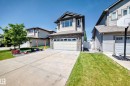 Two-story residence featuring light-colored siding, a stone facade, and a dark shingle roof - 12410 171A Avenue, Edmonton, AB 