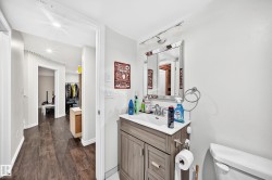 Bathroom vanity featuring a light wood-finish cabinet, white countertop, and rectangular sink - 