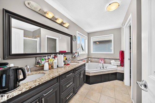 Dual vanity with granite-style countertop and dark wood cabinetry - 12410 171A Avenue, Edmonton, AB 