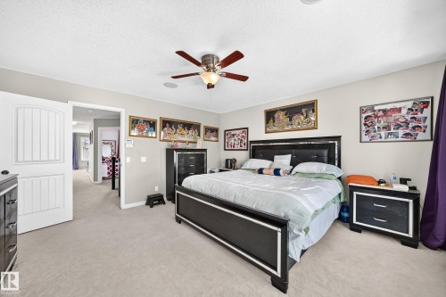 Carpeted room featuring a ceiling fan with integrated lighting, painted walls, and a wide doorway - 12410 171A Avenue, Edmonton, AB 