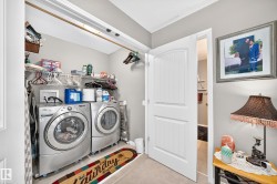 Dedicated laundry area featuring wire shelving, overhead storage, and tile flooring - 