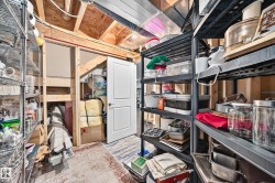 Utility space featuring exposed wood framing, metal shelving, and a paneled white door - 