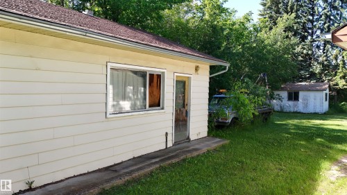 Exterior siding in a cream finish with a brown asphalt shingle roof - 5416 51 Avenue, Andrew, AB 