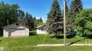 Detached garage with horizontal siding, a single garage door, and a pitched roof - 5416 51 Avenue, Andrew, AB 