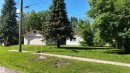 Single-story home featuring white siding, a brown roof, and an attached single-car garage - 5416 51 Avenue, Andrew, AB 