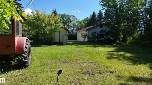 Expansive green lawn with mature trees and a detached shed - 5416 51 Avenue, Andrew, AB 
