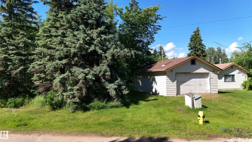 Single-story structure with light-colored horizontal siding and a brown shingle roof - 5416 51 Avenue, Andrew, AB 