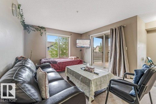 Living space with light beige walls and light-colored carpet flooring - 225 111 Watt Common, Edmonton, AB 