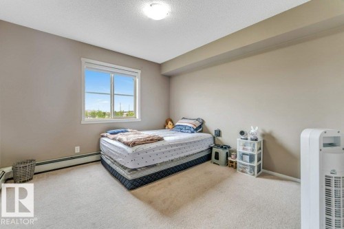 Carpeted bedroom with a window featuring white trim - 225 111 Watt Common, Edmonton, AB 
