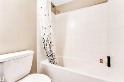 White tiled shower surround with a built-in tub and showerhead - 
