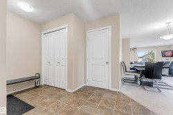 Entryway featuring square tile flooring, a bi-fold closet, and a solid panel door - 