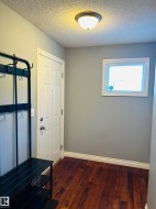 Inviting entryway featuring wood-finish flooring, a paneled door, and a flush-mount ceiling light - 
