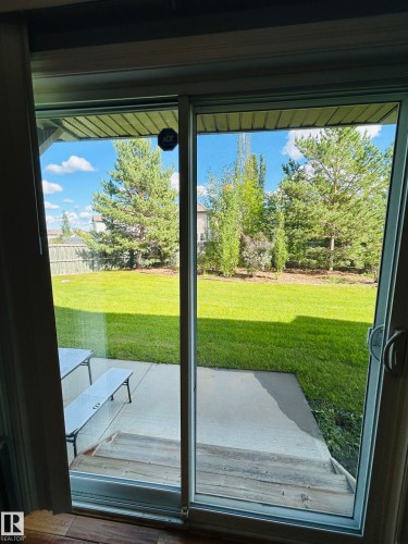 Sliding glass door opening onto a concrete patio with wood-finish steps - 89 12050 17 Avenue, Edmonton, AB 
