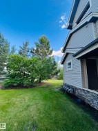 Expansive grassy yard with mature trees and a wood fence - 