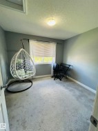Carpeted room featuring a single window with blinds and a flush mount ceiling light fixture - 