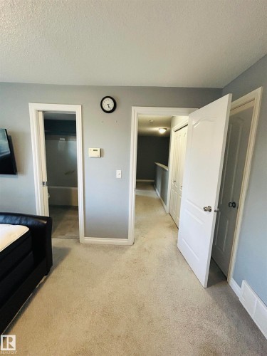 Neutral-toned carpeting extends throughout this interior space, featuring a light gray wall color and white trim - 89 12050 17 Avenue, Edmonton, AB 