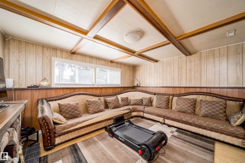 Recreation room featuring wood-finish wall paneling, a coffered ceiling with light-colored panels, and a series of horizontal windows with blinds - 14808 96 Street, Edmonton, AB 