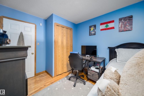 Bedroom featuring wood-finish flooring and light blue walls - 14808 96 Street, Edmonton, AB 