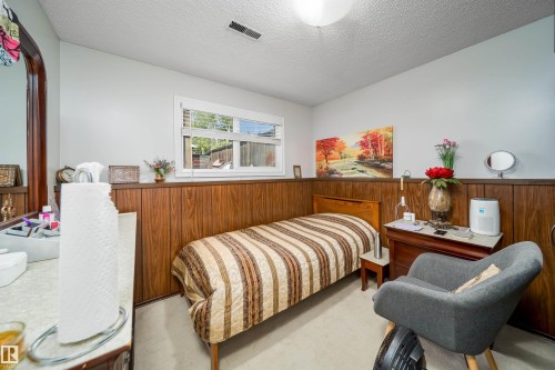 Room featuring light wall paint and lower wood paneling - 14808 96 Street, Edmonton, AB 