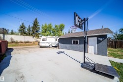Detached garage with stucco exterior and a side entry door - 