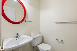 Pedestal sink with chrome faucet and red oval mirror - 