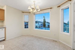 Bright dining area featuring a prominent bay window with white frames and grid patterns - 