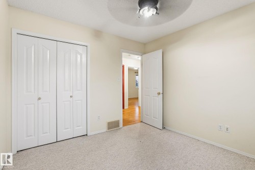 Neutral-toned carpeting paired with light-colored walls and a ceiling-mounted fan - 1906 37B Av, Edmonton, AB 