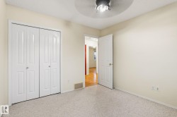 Neutral-toned carpeting paired with light-colored walls and a ceiling-mounted fan - 
