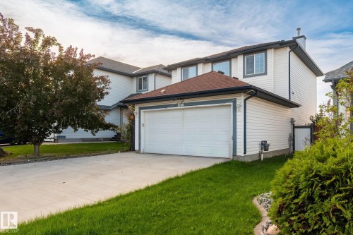 Two-story residence featuring white siding, a two-car garage, and a concrete driveway - 1906 37B Av, Edmonton, AB 