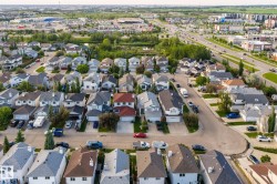 Residential neighborhood featuring detached homes with attached garages, paved streets, and varied rooflines - 