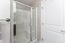 Shower enclosure with clear glass sliding doors and a white composite base - 