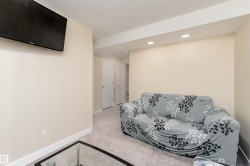 Interior living space featuring recessed lighting, light-colored walls, white trim, and a neutral carpeted floor - 