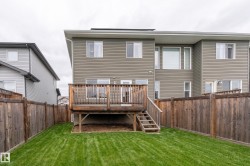 Expansive backyard featuring a manicured lawn, full wood fencing, and a multi-level wood deck with stairs to the yard - 