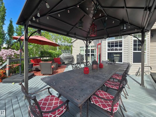Expansive outdoor deck featuring a dark-toned gazebo with integrated lighting and a prominent dining table - 704 Wildwood Point(E), Edmonton, AB 