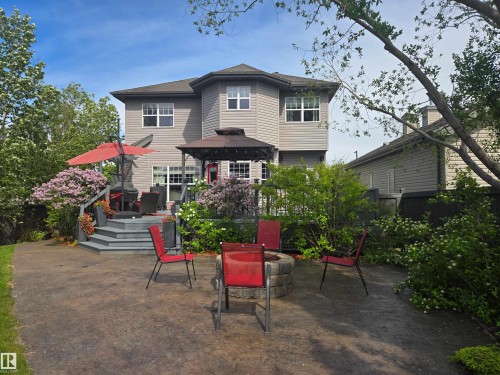 Rear exterior featuring a multi-level deck, a stamped concrete patio, and a built-in stone fire pit - 704 Wildwood Point(E), Edmonton, AB 