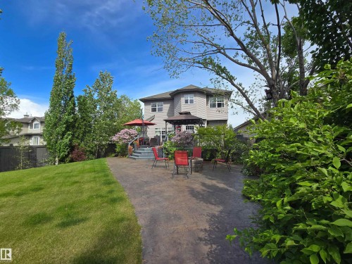 Expansive backyard featuring a large stamped concrete patio, a multi-tiered deck, a built-in gazebo, and mature landscaping with a grassy area - 704 Wildwood Point(E), Edmonton, AB 