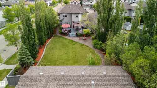 Expansive backyard featuring a manicured lawn, a multi-level deck, and a stone-paved patio - 704 Wildwood Point(E), Edmonton, AB 