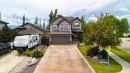 Two-story residence featuring a gray exterior with stone accents and a prominent attached two-car garage - 704 Wildwood Point(E), Edmonton, AB 