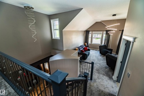 Upper level featuring a vaulted ceiling and a crystal-style chandelier - 704 Wildwood Point(E), Edmonton, AB 