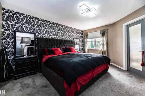 Bedroom featuring a patterned accent wall, neutral painted walls, and textured carpeting - 704 Wildwood Point(E), Edmonton, AB 