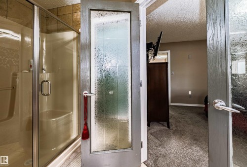 Shower enclosure with clear glass door and integrated seating - 704 Wildwood Point(E), Edmonton, AB 
