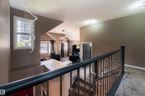 Carpeted stairwell with a wrought iron and wood balustrade - 704 Wildwood Point(E), Edmonton, AB 