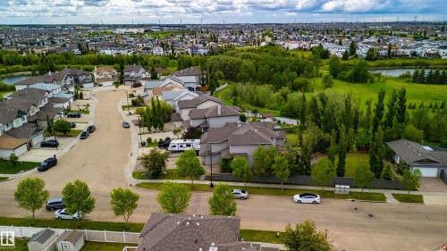 Aerial perspective showcasing a residential neighborhood with detached homes, mature trees, and green spaces - 704 Wildwood Point(E), Edmonton, AB 